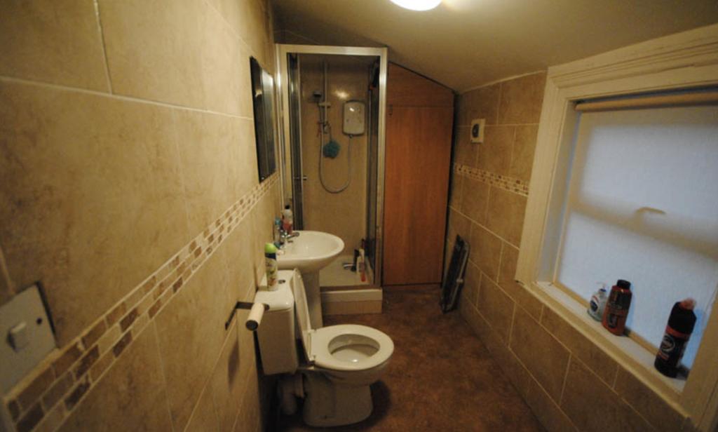 Well-finished bathroom with tiled walls, an enc...
