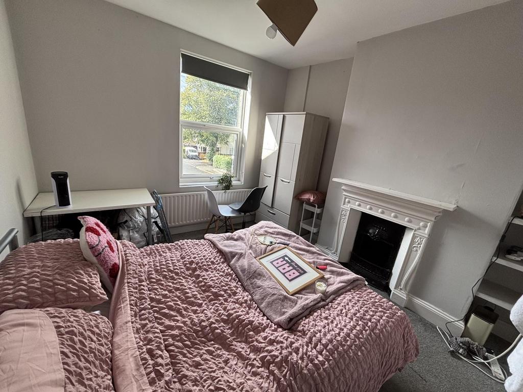 Brightly painted double bedroom with a dressed ...