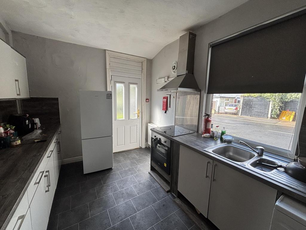 Bright, modern galley kitchen with white cabine...