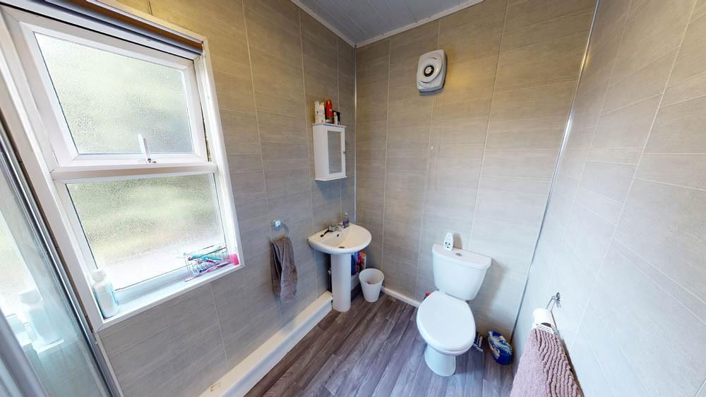 Bright, modern bathroom with a large frosted wi...