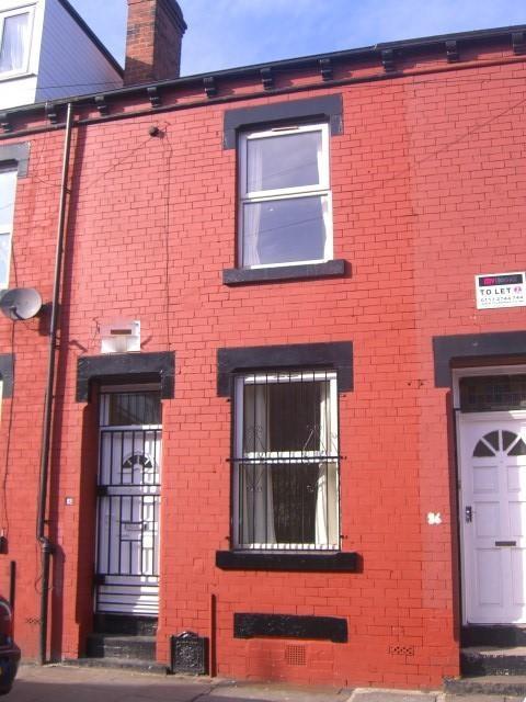 Red-brick terraced house frontage with a street...