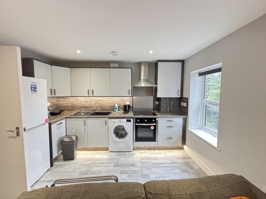 Bright open-plan kitchen with modern white cabi...