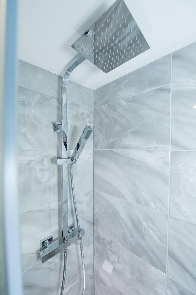 Modern tiled shower with large rainhead and sle...