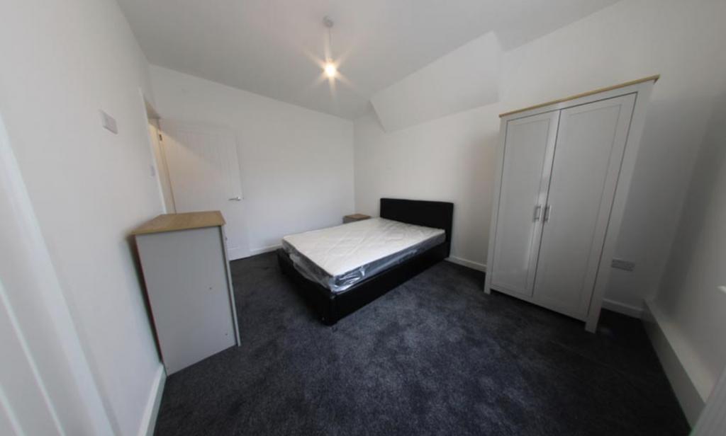 Bright, simply furnished double bedroom with a ...