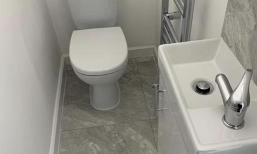 Compact, modern WC with a clean white toilet an...