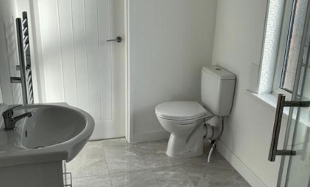 Bright, modern bathroom with tiled floor, pedes...