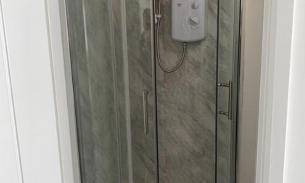 Modern shower cubicle with clear glass doors, c...