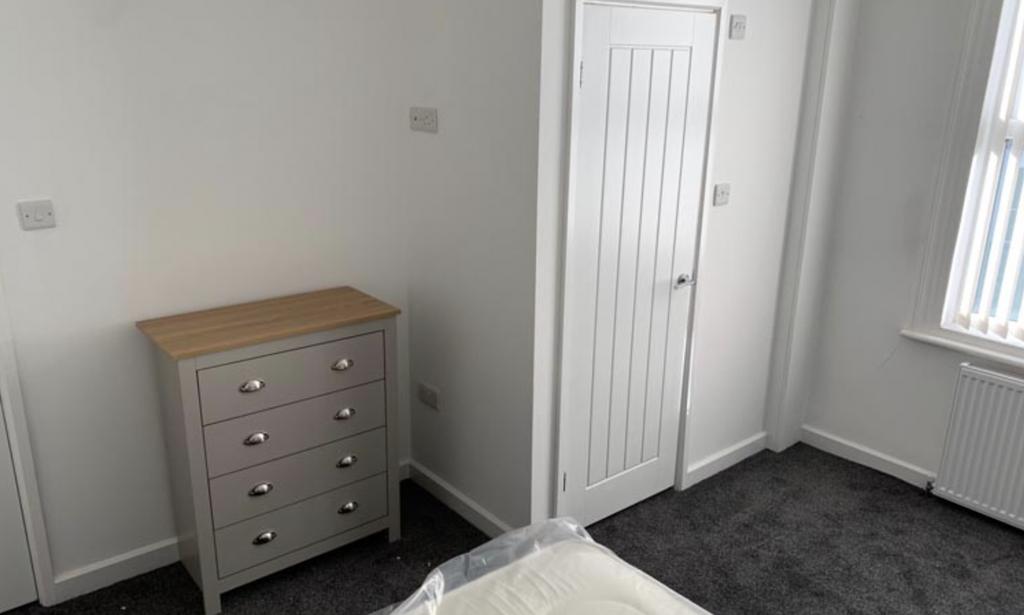 Bright, simply furnished bedroom with neutral d...