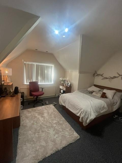 Cozy double bedroom with a neatly made bed, sof...