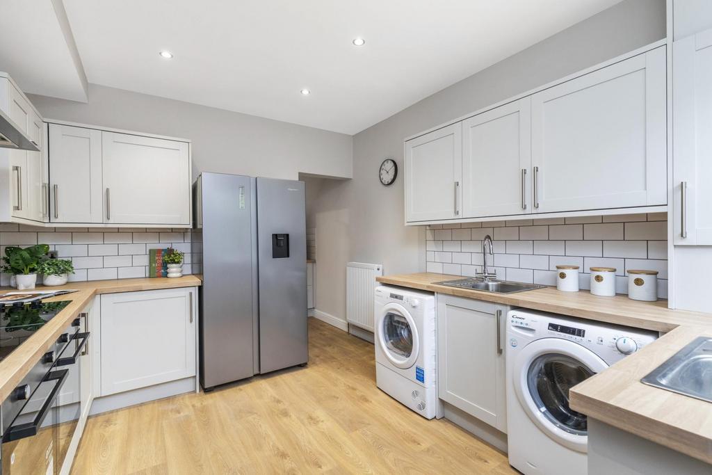 Bright, modern kitchen with light cabinetry, in...