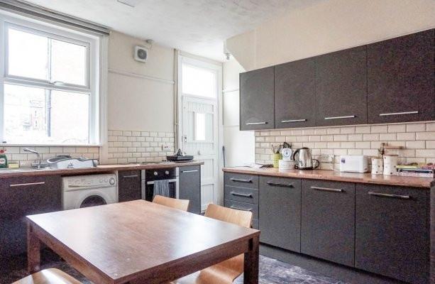 Bright contemporary kitchen with matt dark cabi...