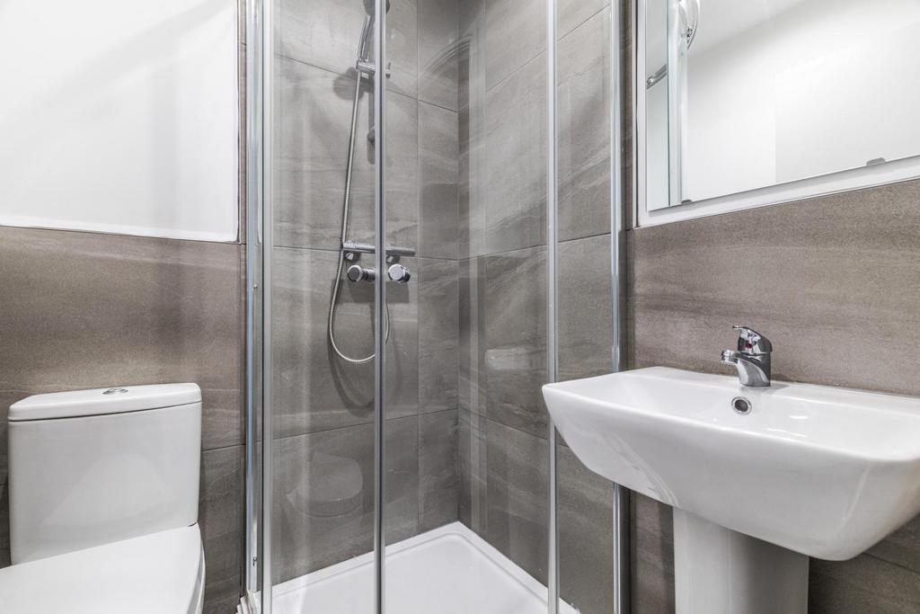 Modern bathroom with a glass-enclosed corner sh...