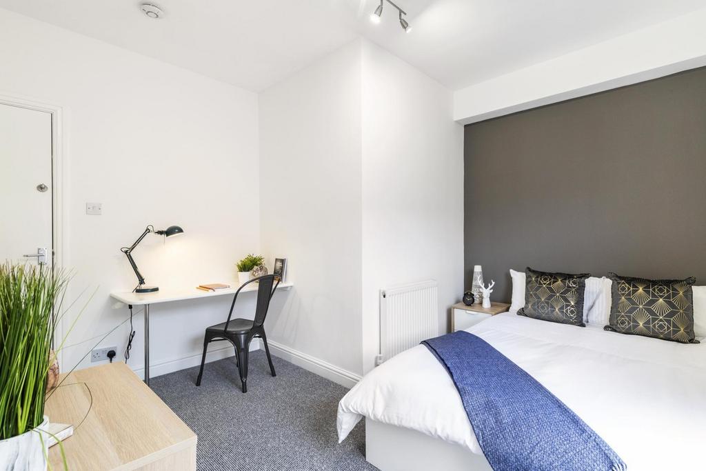 Bright, modern double bedroom with a neatly mad...
