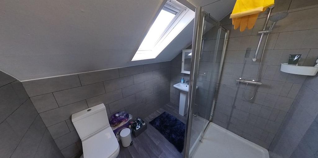 Modern tiled bathroom with a walk-in shower, sk...