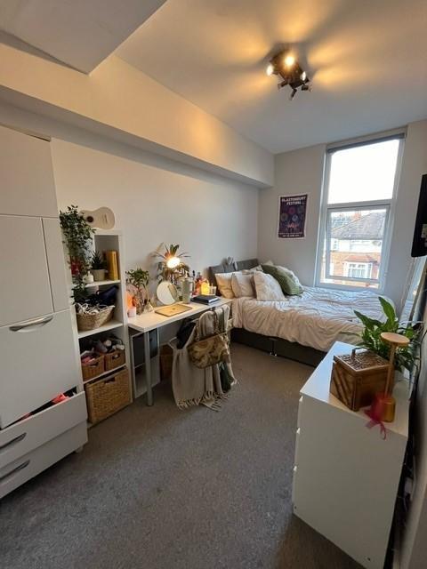 Bright, neatly arranged bedroom with a cosy dou...