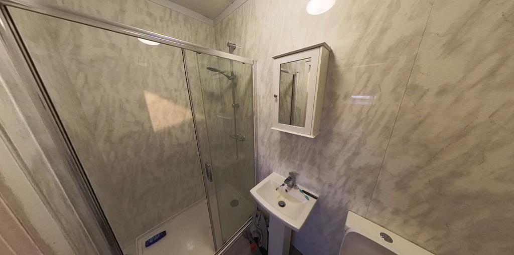 Bright, modern bathroom with a glass-enclosed s...