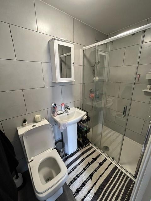 Modern tiled bathroom with a walk-in shower, pe...
