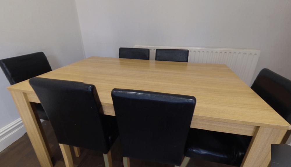 Bright, simple dining area with a wooden table ...