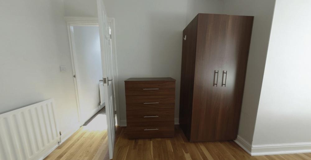 Bright, simply furnished bedroom with wood-effe...