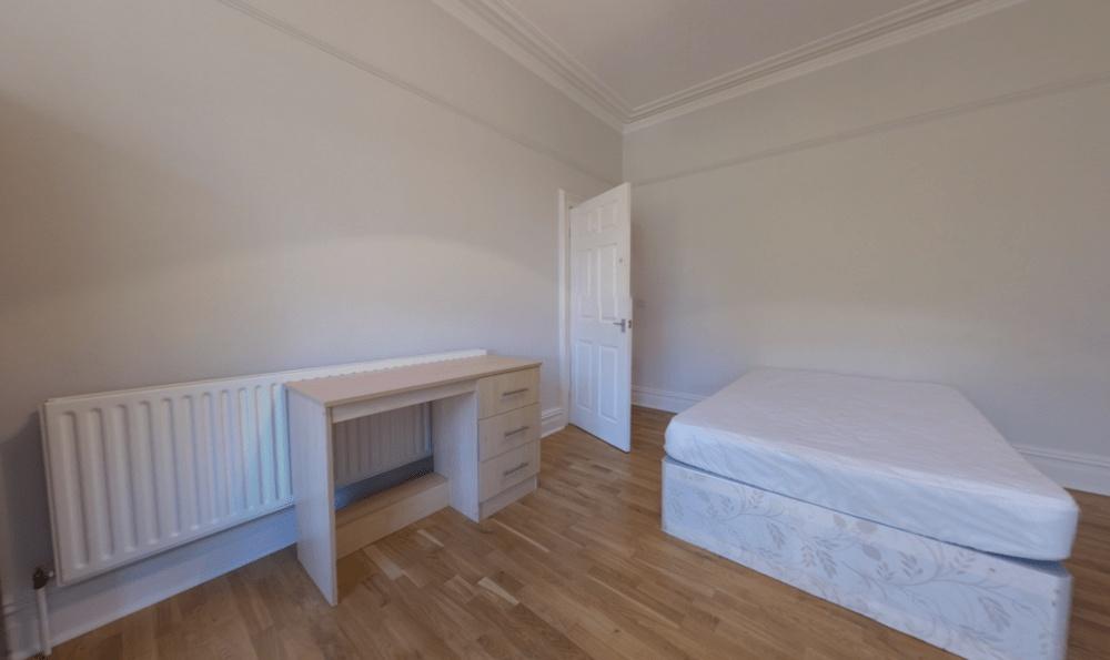 Bright, simply furnished bedroom with a single ...