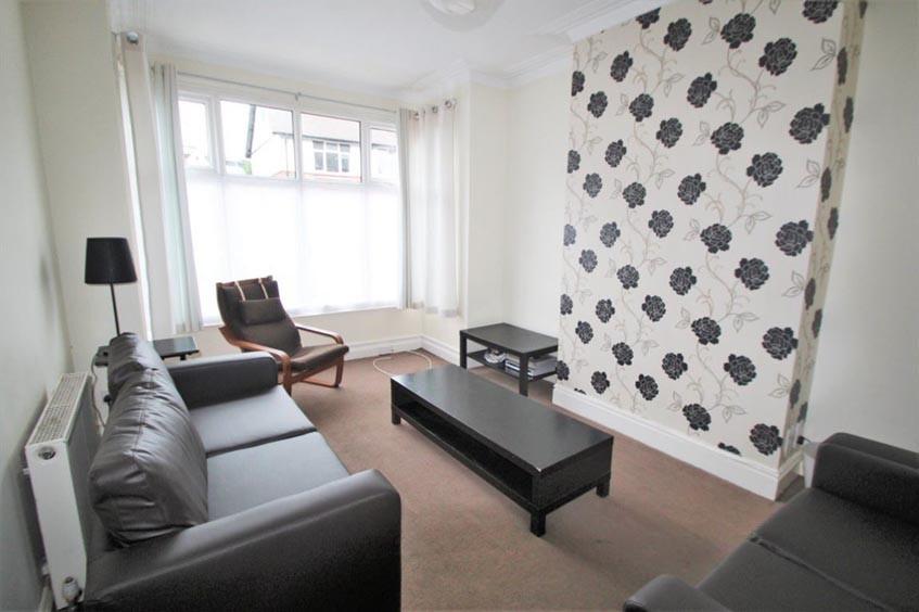Bright living room with a large bay window lett...
