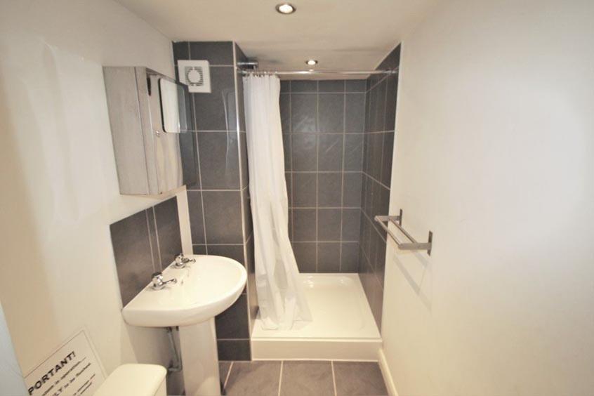 Modern bathroom with tiled bath and shower, ped...