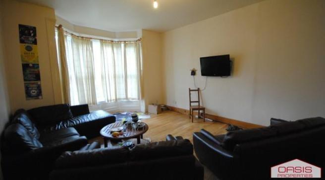 Spacious living room with large bay window fill...