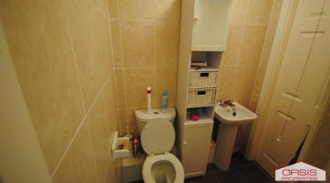 Compact tiled bathroom with a toilet, pedestal ...