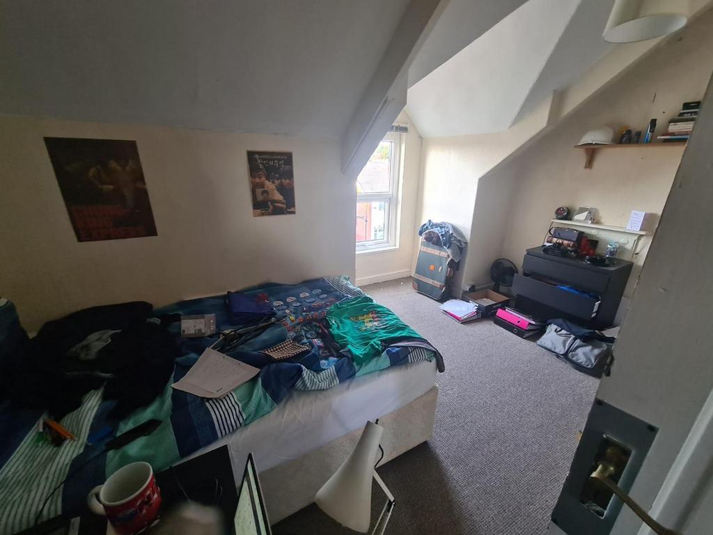 Bright, furnished bedroom with a double bed, bu...