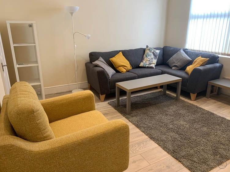 Bright, neatly furnished lounge with a comforta...