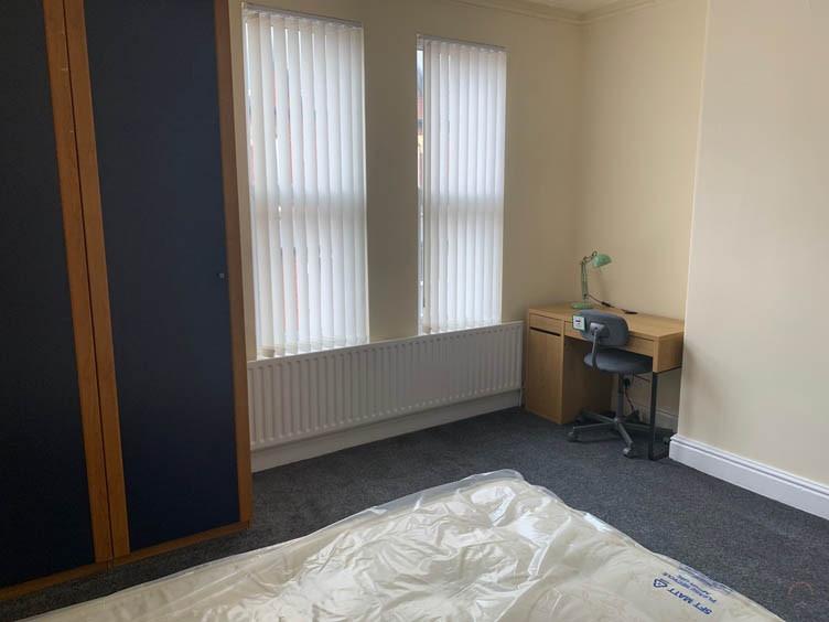 Bright, simply furnished bedroom with large win...