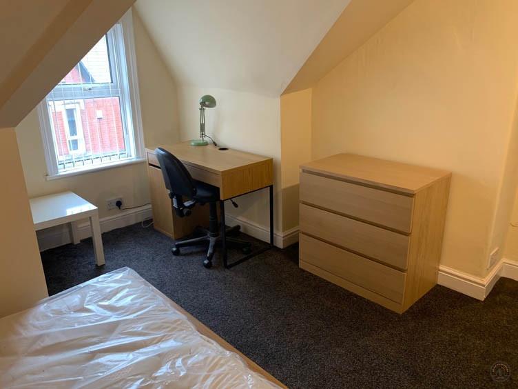 Bright attic-style single bedroom with a pitche...