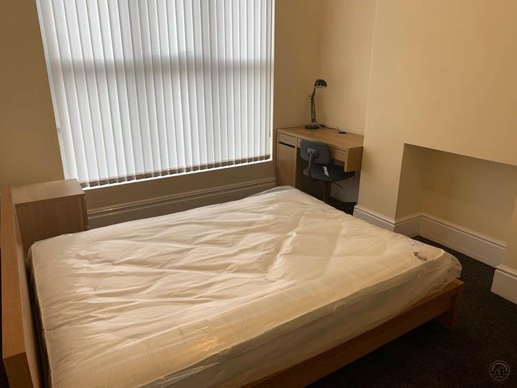 Bright double bedroom with a large window, mode...