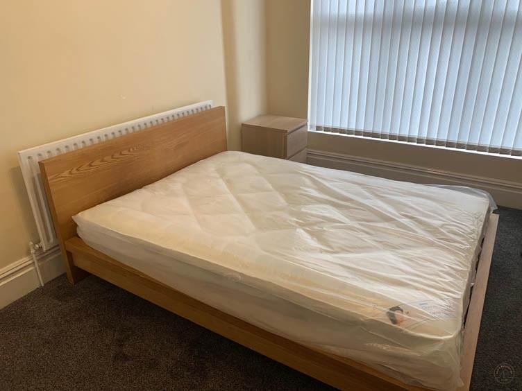 Bright, simply furnished bedroom featuring a mo...