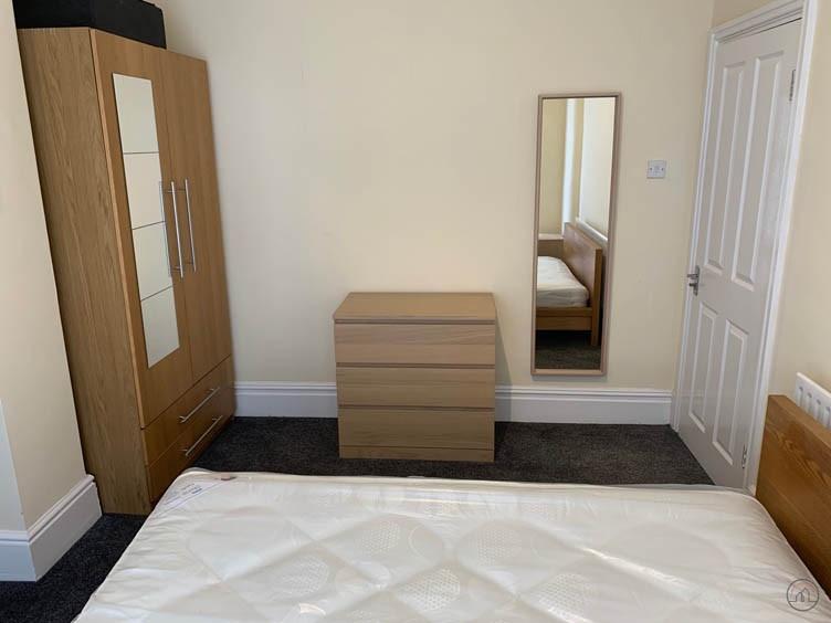 Bright, simply furnished bedroom with a double ...