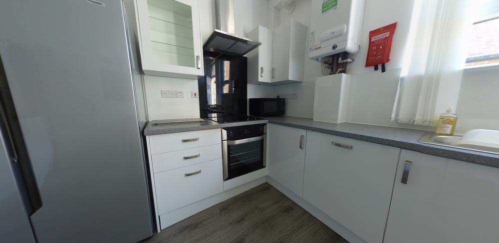 Bright, modern galley kitchen with integrated o...