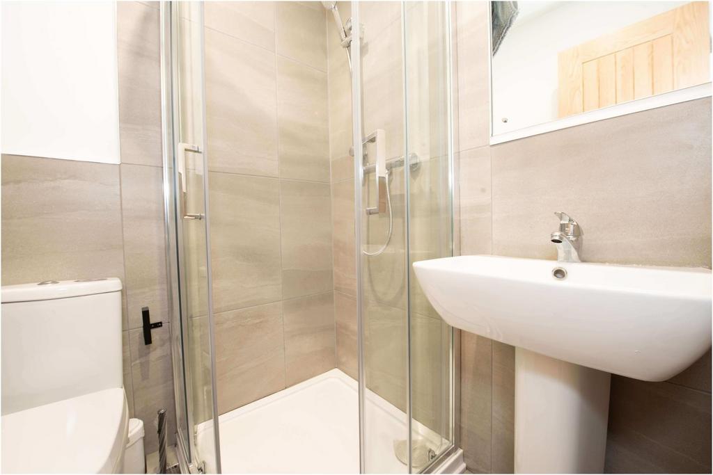 Bright, modern bathroom featuring a glass-enclo...