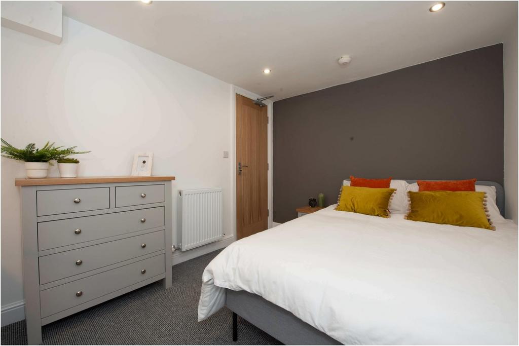 Bright, modern double bedroom with neutral deco...