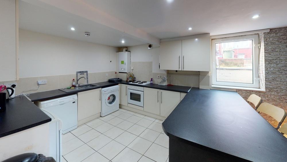 Bright, modern kitchen with white cabinets, int...