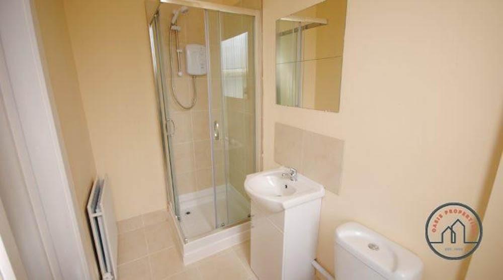Bright, modern bathroom with a corner glass sho...