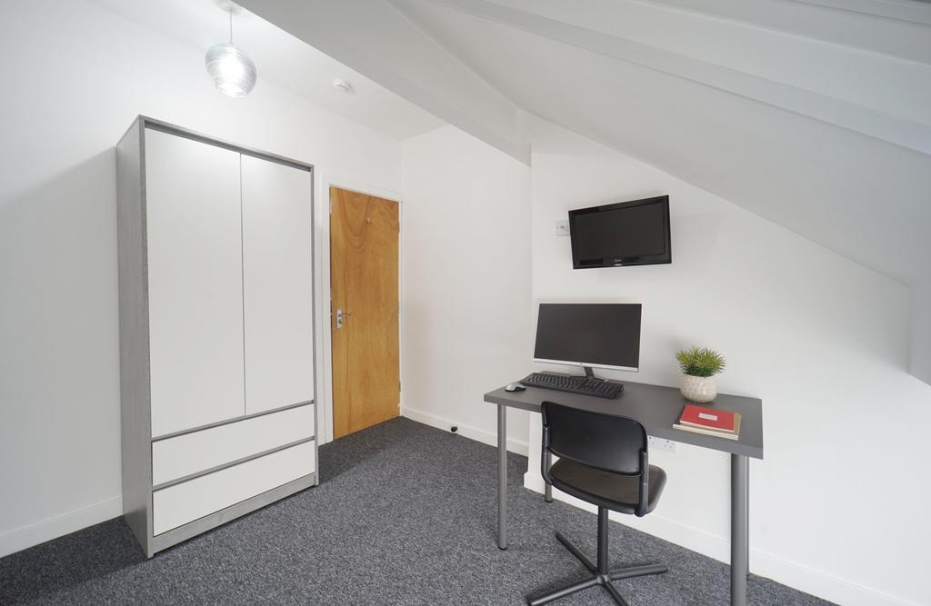 Brightly painted attic single bedroom with slop...