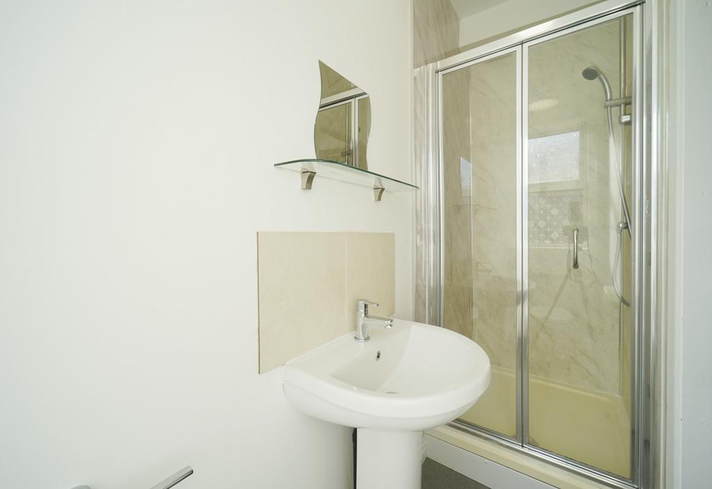 Bright, modern bathroom with a pedestal sink, m...
