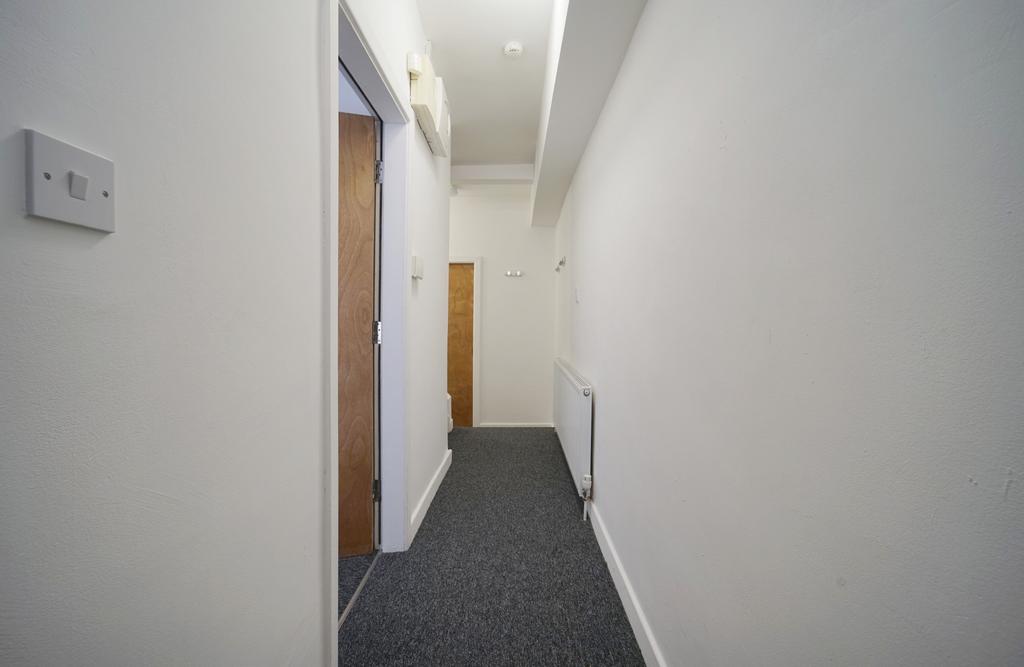 Clean, simple interior hallway with neutral whi...