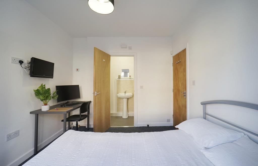 Bright, modern double bedroom with a neatly mad...