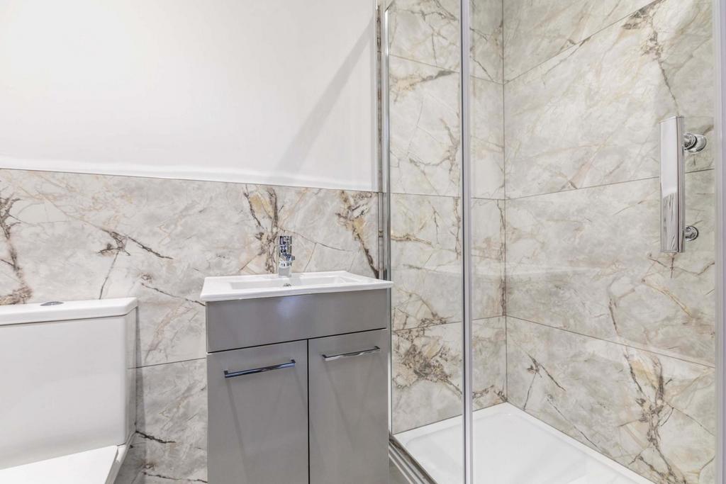 Modern bathroom with stone-effect wall tiles, g...
