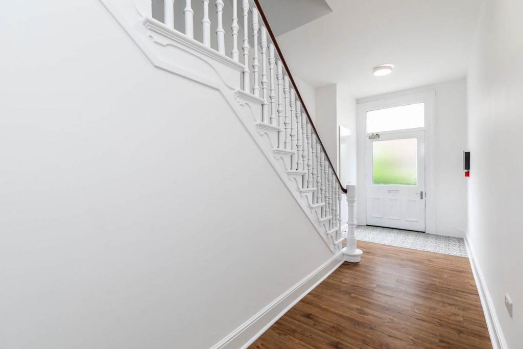 Bright, modern entrance hallway with clean whit...