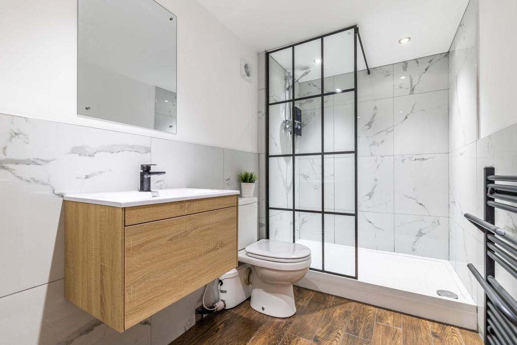 Modern bathroom with marble-effect tiled walls,...