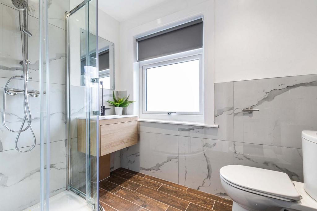 Bright, modern bathroom with a walk-in glass sh...