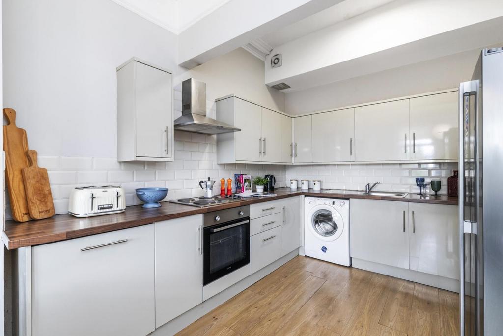 Modern fitted kitchen with glossy cream cabinet...