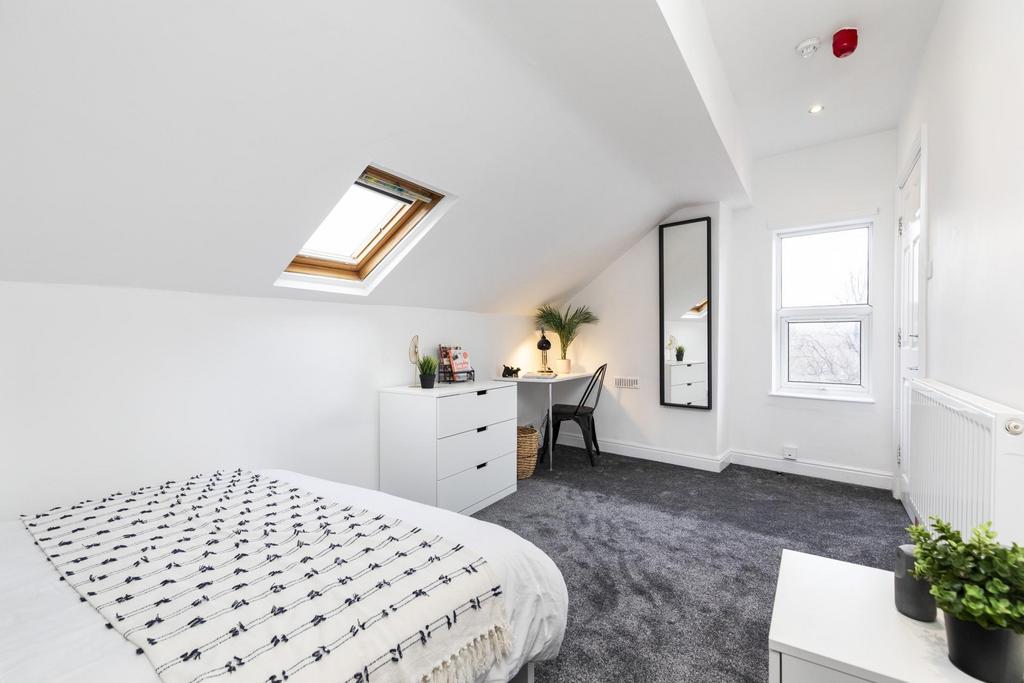 Bright attic bedroom with a double bed, skyligh...